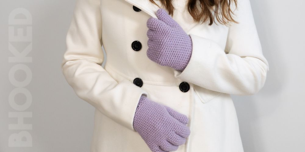 Purple crochet gloves worn with a white coat.